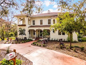 Elegant two-story home boasts a charming facade, complemented by a terra cotta-colored driveway and lush landscaping at 2004 Magnolia Ave, Sanford, FL 32771