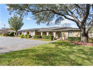 Building exterior showcasing a charming building with lush landscaping and ample parking at 208 Diamond Cv # 104, Casselberry, FL 32707
