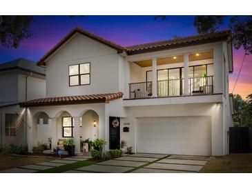 Stunning two-story home featuring a tile roof, balcony, arched entryway, and a well-manicured front yard at 2309 Depauw Ave, Orlando, FL 32804