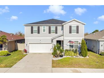 Two-story house with gray siding, white garage door, and landscaping at 275 Sunfish Dr, Winter Haven, FL 33881