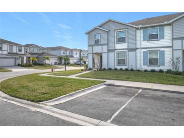 Two-story townhome with gray siding, landscaped lawn, and driveway parking at 3798 Lana Ave, Davenport, FL 33897