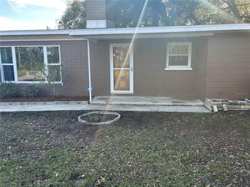 House exterior featuring a brown brick facade, front entrance, and landscaping at 423 Longfellow Blvd, Lakeland, FL 33801