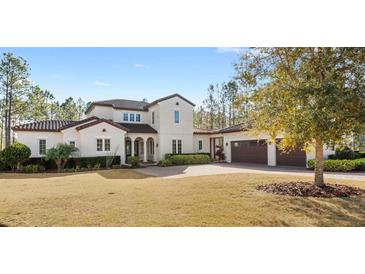 Two-story house with tile roof, large windows, and a three-car garage at 506 Yellow Submarine Ct, Groveland, FL 34737