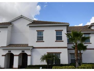 Charming two-story home with tan trim, brown tile roof, and a neatly landscaped front yard at 9023 Dogleg Dr, Davenport, FL 33896
