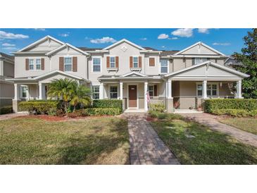 Charming townhome with landscaped front yard, brick walkway and covered front porch at 13829 Ingelnook Dr, Windermere, FL 34786