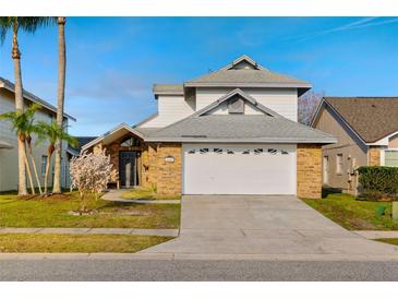 Charming two-story home featuring a two-car garage, brick accents, mature landscaping, and a well-maintained lawn at 14607 Traders Path, Orlando, FL 32837