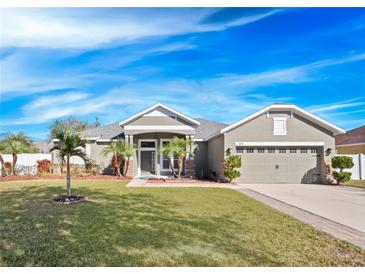 Single-story house with a two-car garage and palm trees at 3291 Pawleys N Loop, St Cloud, FL 34769