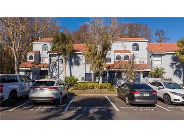 Well maintained two-story townhome with a tile roof, reserved parking, and mature landscaping at 4765 Capri Pl # 209, Orlando, FL 32811