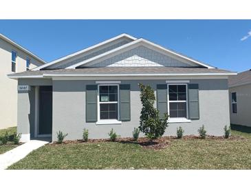 Charming single-story home featuring a well-manicured lawn and quaint window shutters on a sunny day at 5879 Galloping Dr, Apopka, FL 32712