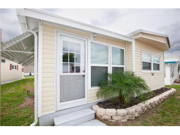 Charming home exterior featuring a well-manicured lawn and stone-lined garden at 662 Sinclair Cir, Tavares, FL 32778