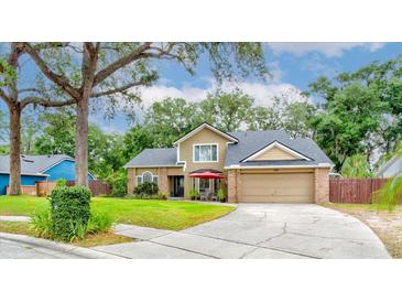 Inviting two-story home with a lush front yard, covered entryway, and attached two-car garage, under a shade tree at 848 Bucksaw Pl, Longwood, FL 32750