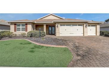 Inviting home featuring manicured lawn, mature landscaping, and a three-car garage at 9058 Sw 89Th Loop, Ocala, FL 34481