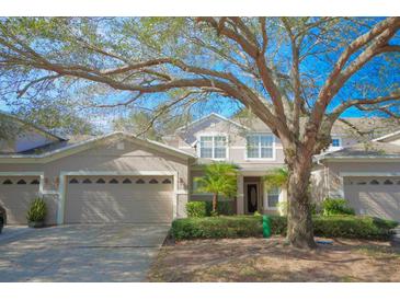 Two-story townhome with attached garage and lush landscaping at 980 Crestwood Commons Ave, Ocoee, FL 34761