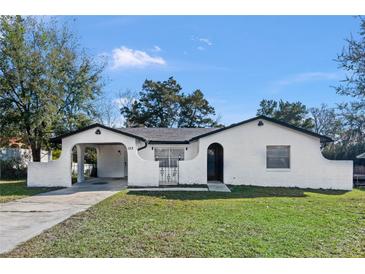 Charming home featuring unique architecture, an arched entry, and a well-maintained front yard at 1113 Leeward Dr, Deltona, FL 32738
