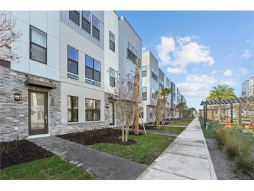 Modern townhome exterior with brick accents, sidewalk, landscaping, and community pergola at 2225 Valentine Aly, Orlando, FL 32804