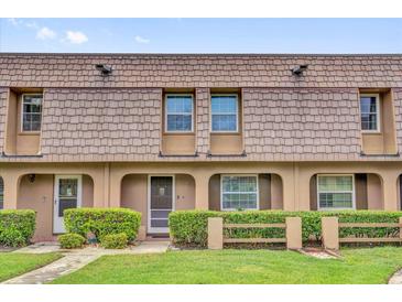 Charming townhouse featuring manicured landscaping, covered entrance and shingled facade at 3104 Harrison Ave # 11, Orlando, FL 32804