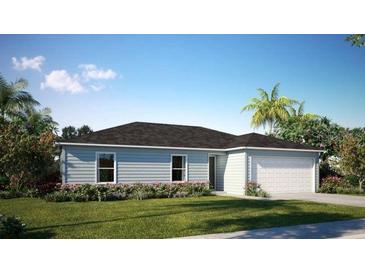 Single-story home with a two-car garage and landscaped lawn at 590 E Division W St, Deland, FL 32724