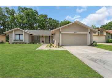 Charming single Gathering home with a well-manicured lawn, two-car garage and beautiful landscaping at 605 Marni Dr, Winter Springs, FL 32708