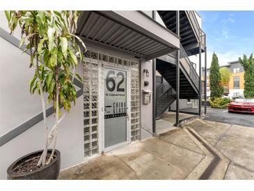 Close-up of the building entrance with glass block windows and an industrial-style metal awning and stairwell at 62 W Colonial Dr # 302, Orlando, FL 32801