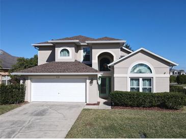 Charming two-story home featuring a manicured lawn and an attached two-car garage at 8130 Yellow Crane Dr, Kissimmee, FL 34747