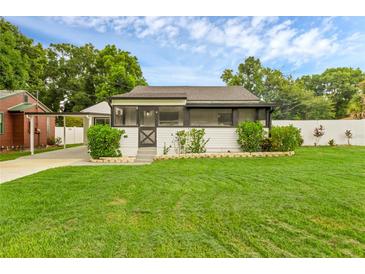 Charming home with well-maintained lawn and partially screened front porch at 1211 Dorothy St, Lakeland, FL 33815