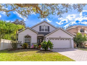 Charming single Gathering home featuring well-maintained landscaping and a paved driveway at 12918 Hunters Vista Blvd, Orlando, FL 32837