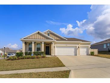 Charming single-story home featuring a three-car garage, well-manicured lawn, and welcoming entryway at 14436 Topaghan Way, Winter Garden, FL 34787