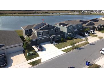 Aerial view of a two-story house with solar panels and a lake in the background at 4390 Bull St, St Cloud, FL 34772