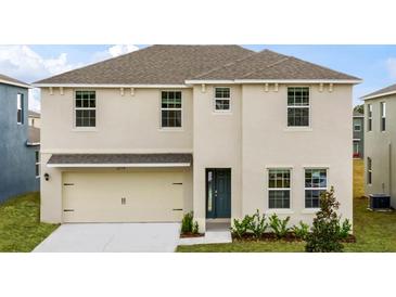 Two-story house with beige siding, two-car garage, and landscaping at 4601 Boxwood Way, Mount Dora, FL 32757