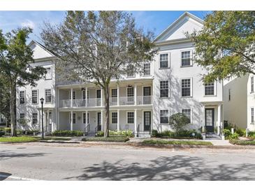 White townhouses with balconies, trees, and a street at 4713 Anson Ln, Orlando, FL 32814