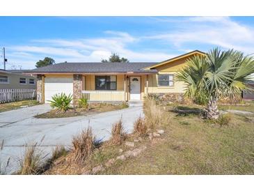 House exterior featuring a yellow-painted house with a stone facade and a driveway at 5953 Bolling Dr, Orlando, FL 32808