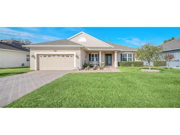 Charming single-story home featuring a manicured lawn, brick pathway, and inviting entryway at 1012 Everest St, Clermont, FL 34711