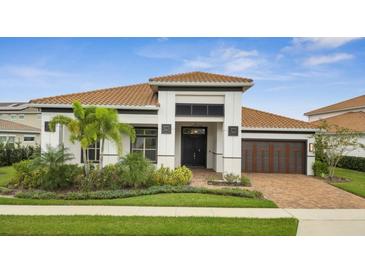 Charming single-story home featuring a tile roof, meticulously landscaped yard, and an attached two-car garage at 13265 Alderley Dr, Orlando, FL 32832