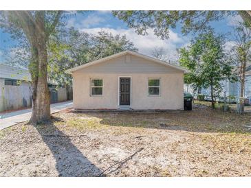 Quaint single-story home featuring neutral stucco, gray trim, and a compact front yard at 424 S Observatory Dr, Orlando, FL 32835