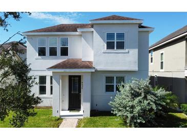 Two-story house with white exterior, brown roof, and landscaped lawn at 4636 Southlawn Ave, Orlando, FL 32811