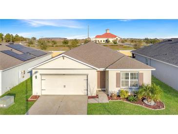 Inviting single-story home with manicured lawn and solar panels for energy efficiency at 651 Tortugas St, Haines City, FL 33844