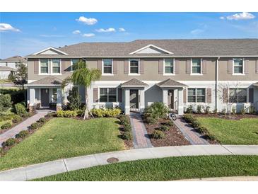 Charming townhome featuring manicured landscaping, brick walkways, and a freshly painted facade at 12043 Holystone St, Winter Garden, FL 34787