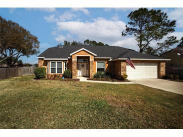 One-story house with a brick facade, a two-car garage, and a well-maintained lawn at 12826 Forestedge Cir, Orlando, FL 32828