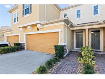 Charming two-story home with a well-manicured lawn and an attached two-car garage at 17438 Promenade Dr, Clermont, FL 34711