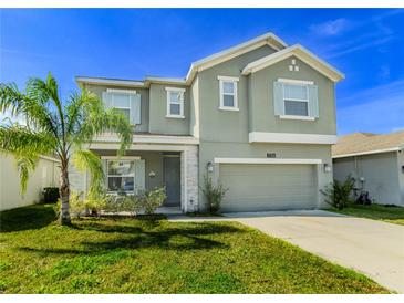 Two-story house with green exterior, two-car garage, and palm tree at 1756 Chatsworth Cir, St Cloud, FL 34771