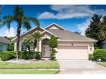 Charming single-story home featuring a well-manicured lawn, mature palm trees, and an attached two-car garage at 1809 Wedgewood Way, Kissimmee, FL 34746