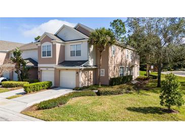 Charming townhome with a well-manicured lawn, lush shrubbery, and attached two-car garage at 2011 Stockton Dr, Sanford, FL 32771
