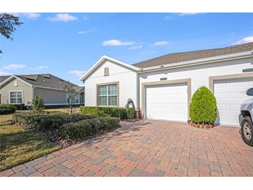 Charming single-story home featuring a well-maintained lawn and a two-car garage with a brick-paved driveway at 3541 Belland Cir # A, Clermont, FL 34711