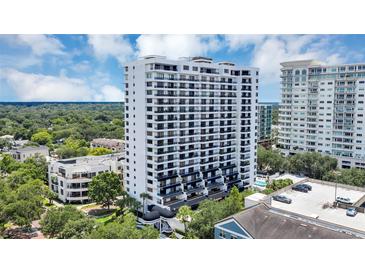 A high rise condo building with an intricate balcony design stands out against lush green landscape under bright blue skies at 530 E Central Blvd # 102, Orlando, FL 32801