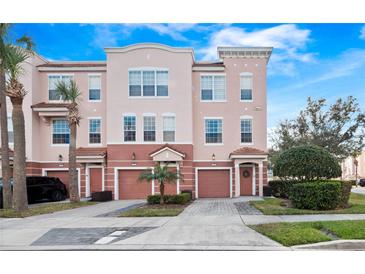 Three-story townhome with two-car garage and landscaped front at 8013 Cool Breeze Dr # 116, Orlando, FL 32819