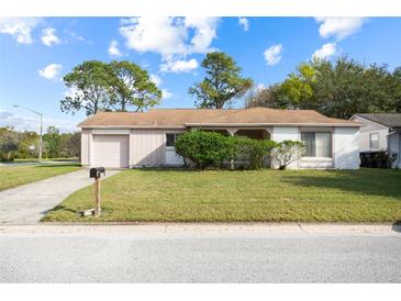 Charming single-story home with a well-maintained lawn and a driveway leading to an attached garage at 10305 Licorice Way, Orlando, FL 32821