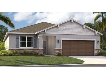 One-story home with gray siding, brown garage door, and stone accents at 1204 White Ash Loop, Deland, FL 32720