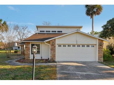 Charming home exterior features stone accents and a two-car garage with decorative windows at 124 Loon Ct, Daytona Beach, FL 32119