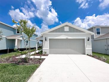 Well-maintained home featuring a gray exterior, a two-car garage, and a concrete driveway at 2206 Lovely Ln, Davenport, FL 33897
