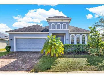 Charming single-story home features a well-manicured lawn, grey paint, and a two-car garage at 332 Terracotta Ter, Howey In The Hills, FL 34737